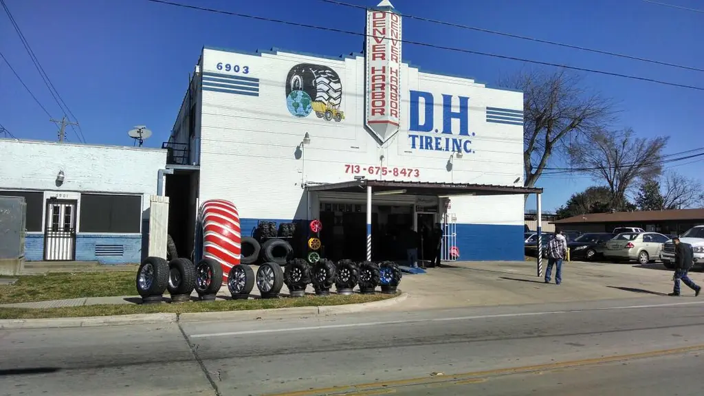 The D H Tire storefront on Lyons Ave with the painted company sign and the phone number on the building