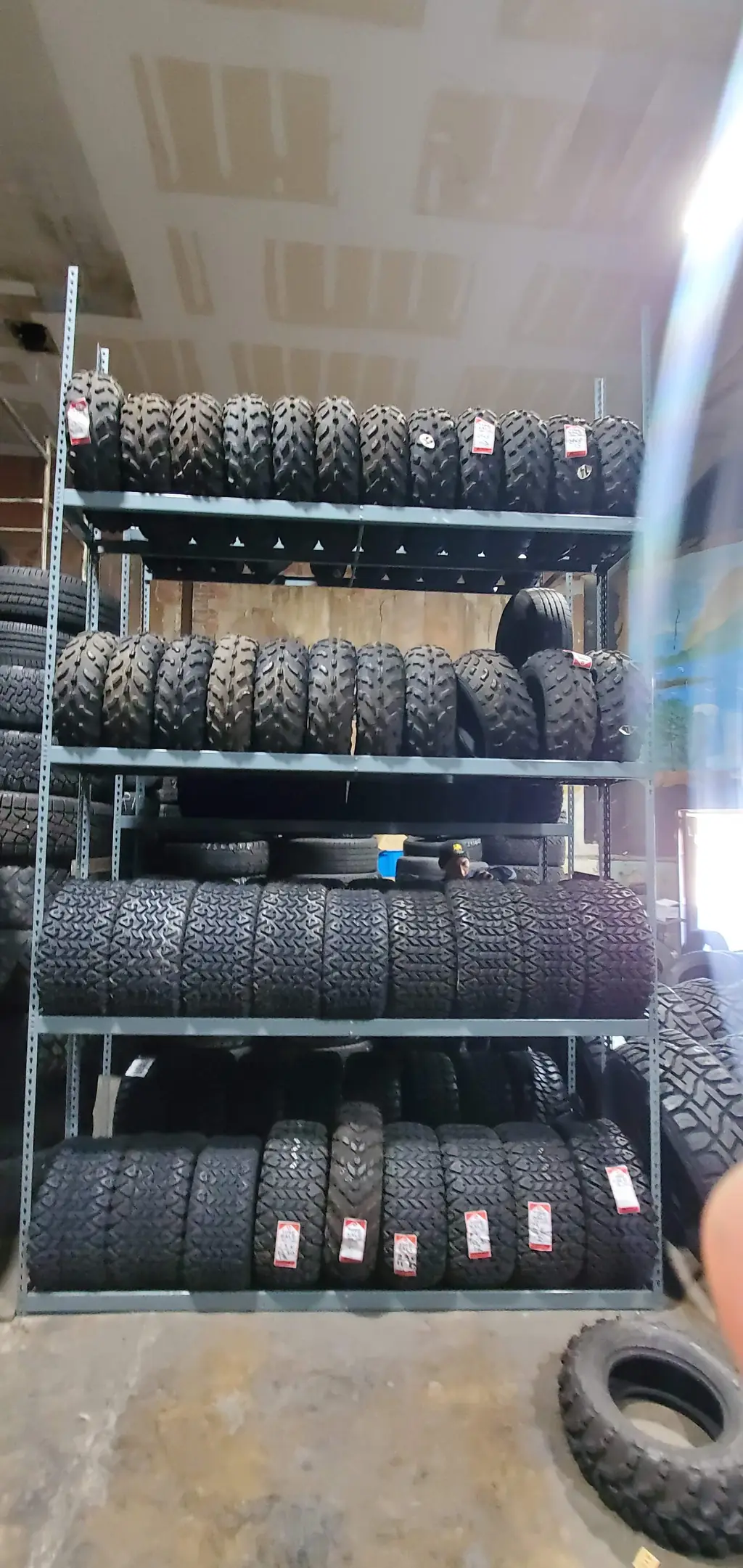 Shelving at D H Tire stacked with tire inventory and visible price tags