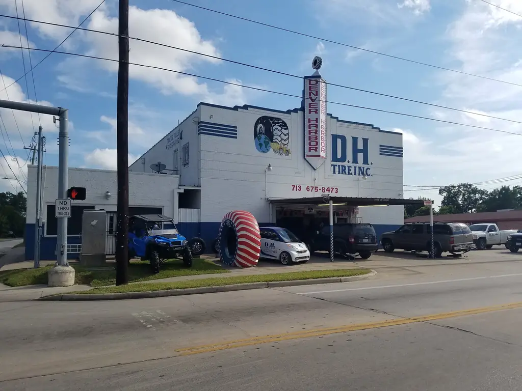 The D H Tire building on Lyons Ave in Houston, with the company branded car parked outside
